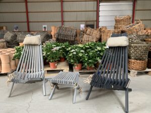 To deck chair står foran planter, kurve og krukker på lageret