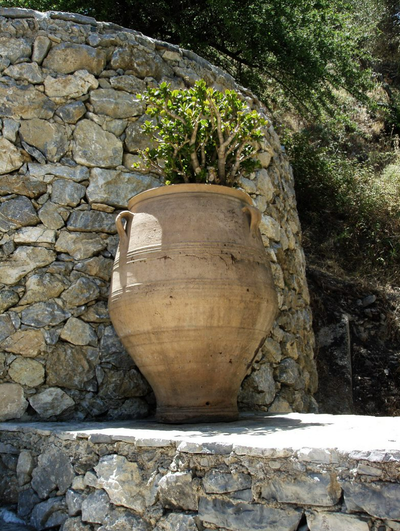 Bala krukke med en busk står ved kampsten på Kreta